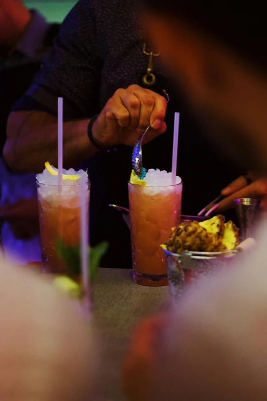 three people in line at a bar, eating and having beverages