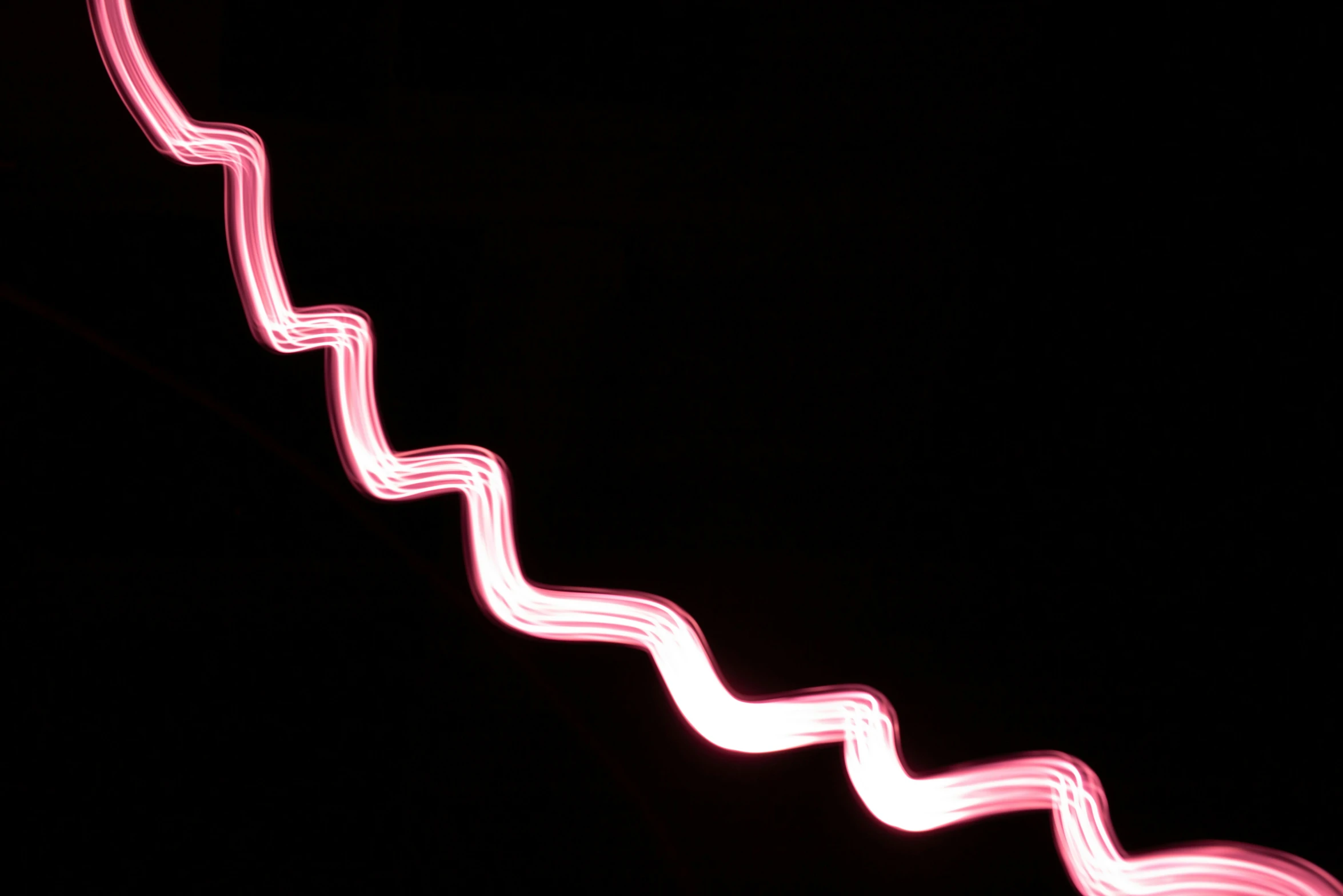 light streaks are creating a pattern against a black background