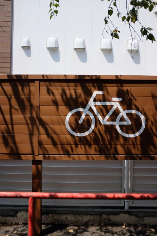 a sign that says bike on it near a red fence