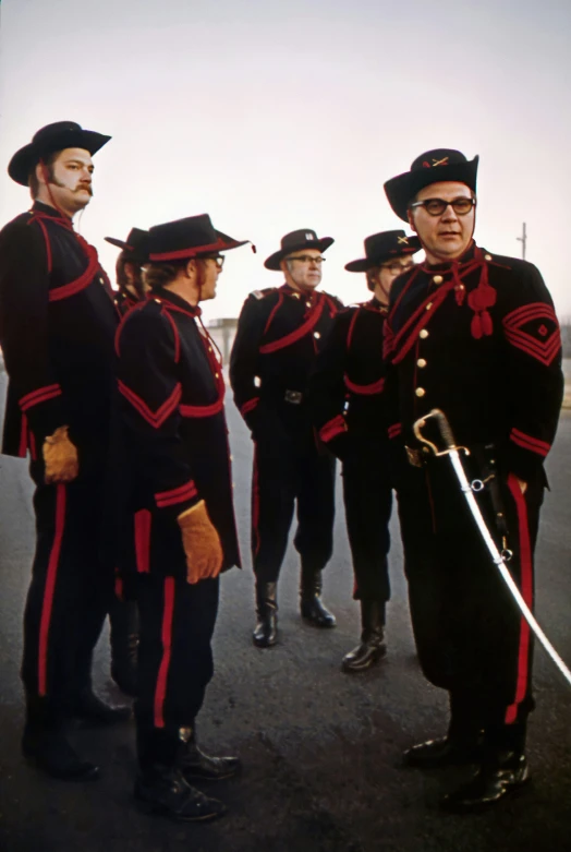 a group of men in uniforms and hats standing in a circle