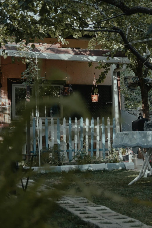 a small white picket fence in front of a red building