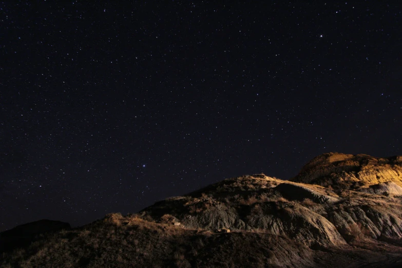 the night sky is very clear with stars on the mountain