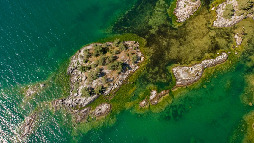 an island is surrounded by green waters