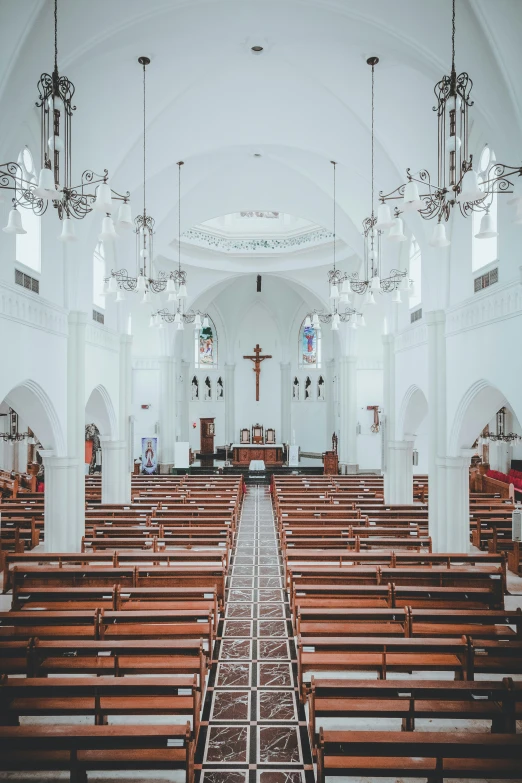 empty church pews and chandeliers with stained glass windows