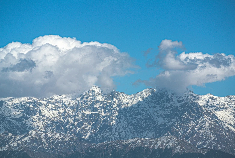 a large mountain range with clouds in the sky