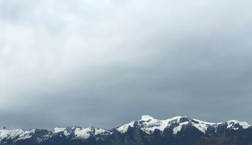 some snow mountains under a cloudy sky