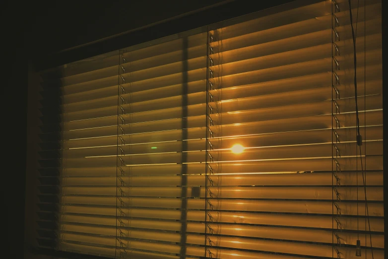 a close up of a window blinds with the light on