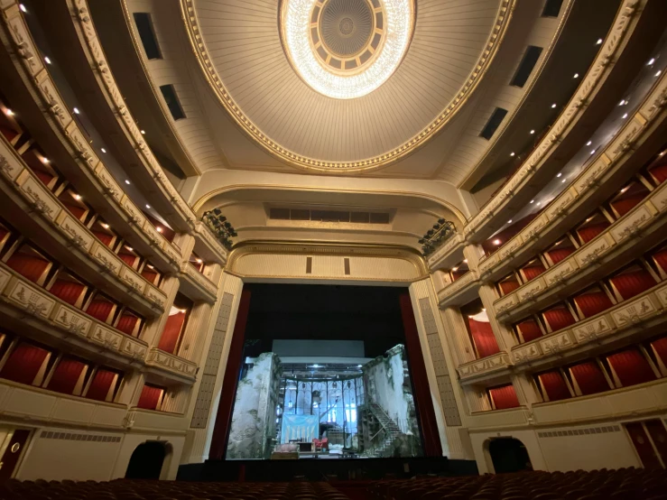 the large auditorium has lights, a ceiling and pillars