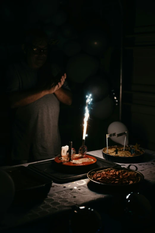 a man is making a wish with a small sparkler