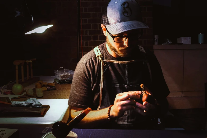 a man with glasses and a hat operating a pipe