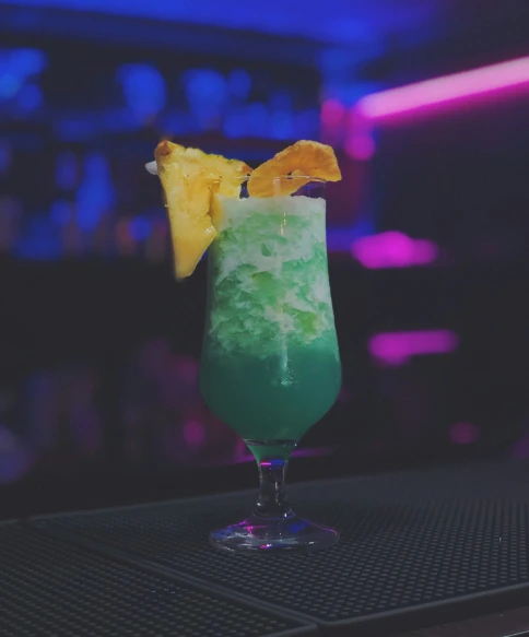 a green cocktail with fruit in the top of it