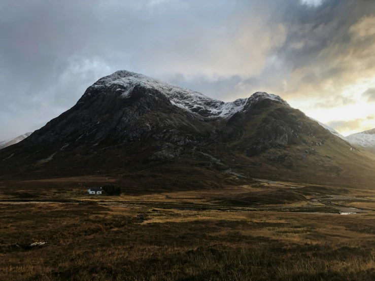 there is a mountain with a few snow capped on it