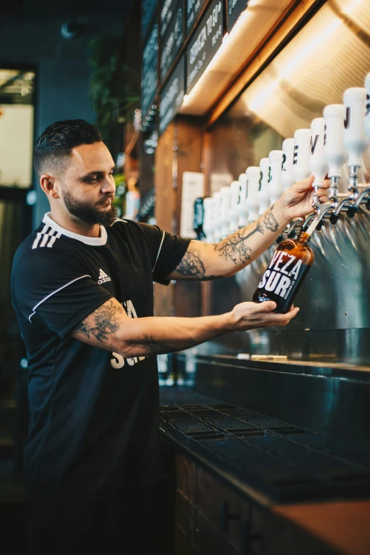 a man standing at a beer bar filling a bottle