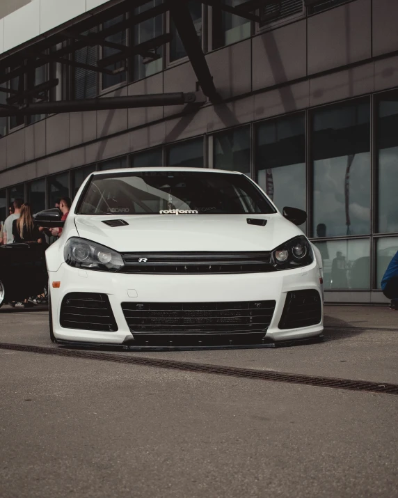 two white cars are parked near each other in front of a building