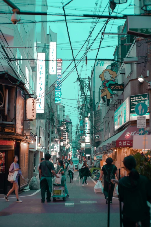 people walking down an asian city street in the late evening