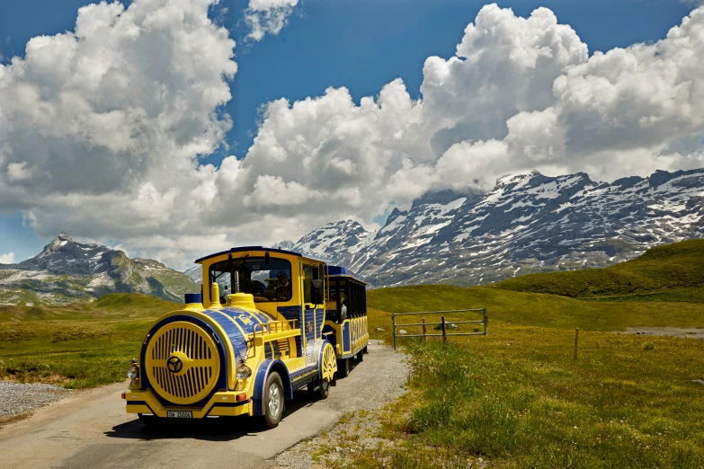 a yellow truck sits on the road in a field