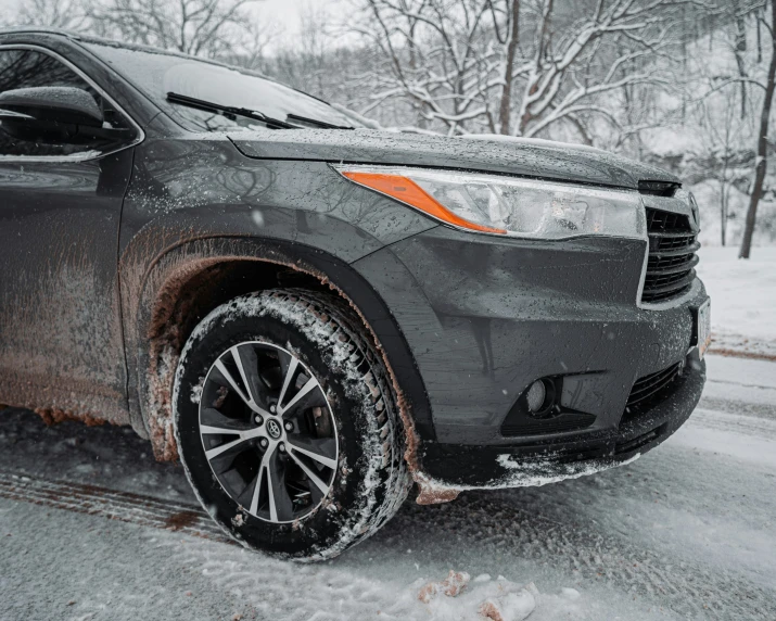 the snow covered vehicle is parked on the side of the road