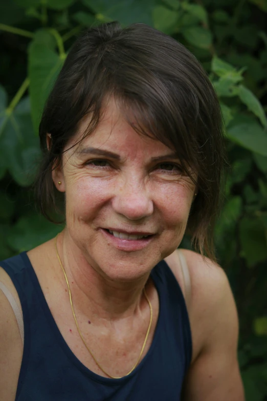 a woman wearing a blue top is smiling