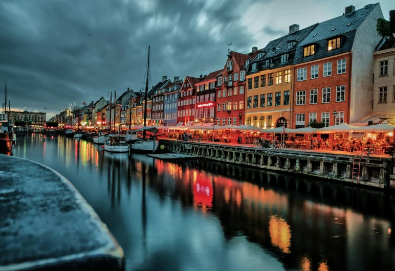 several boats are parked in the water at night