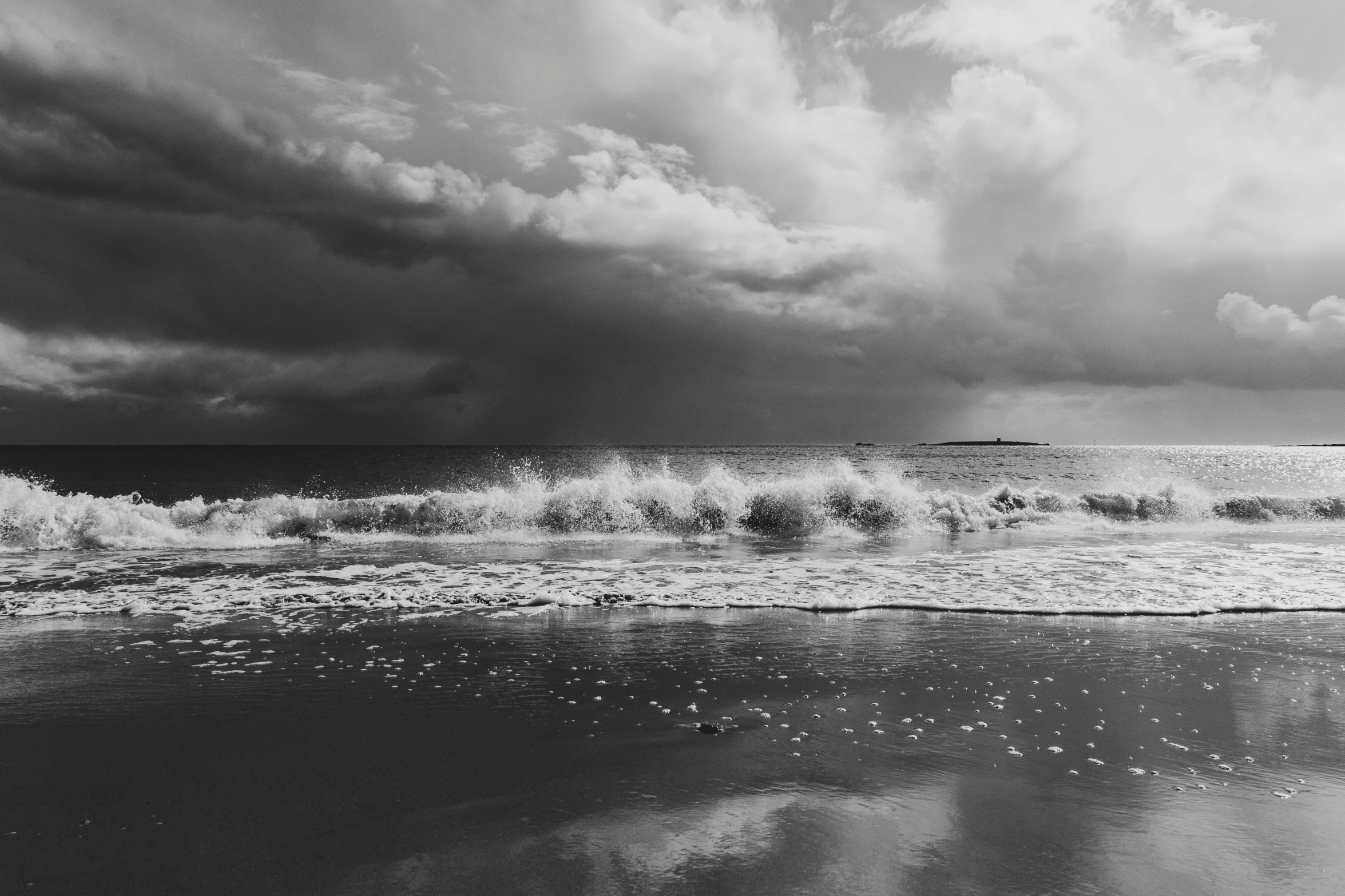 a person walks on the beach towards the water