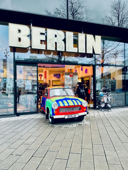 an old car is in front of a berlin shop
