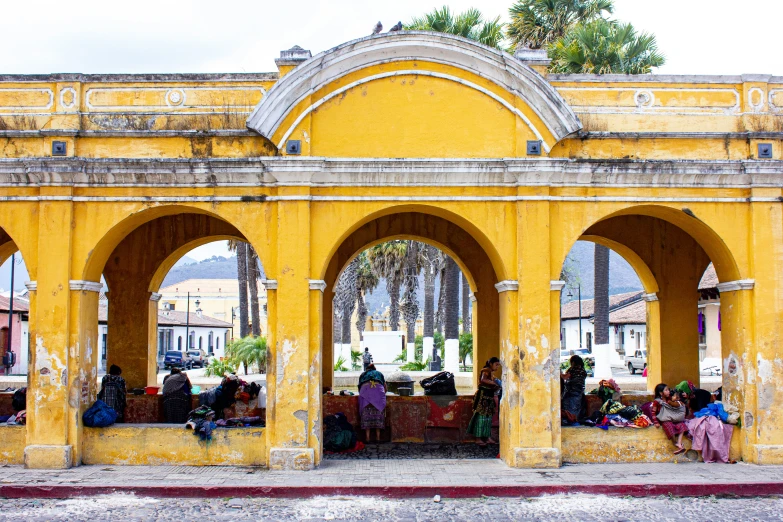 an archway is shown with some people sitting under