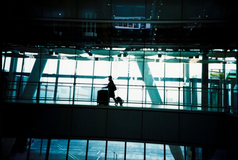 an airport lobby with people holding luggage