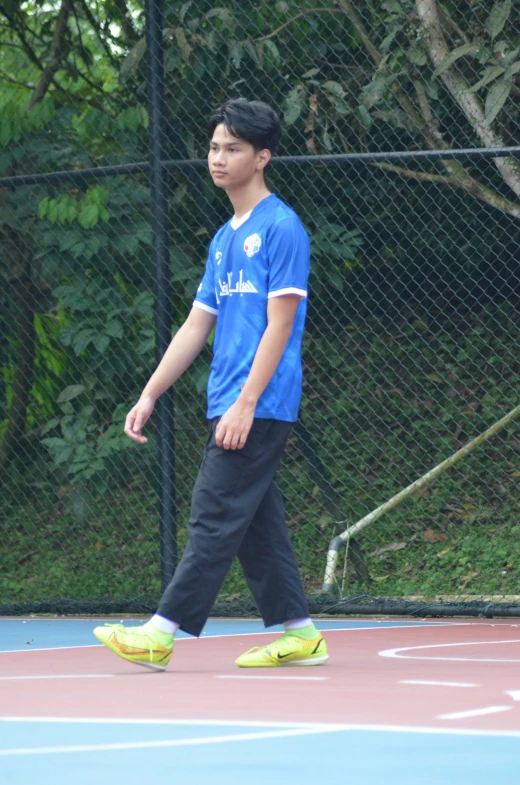 a young man standing on top of a tennis court