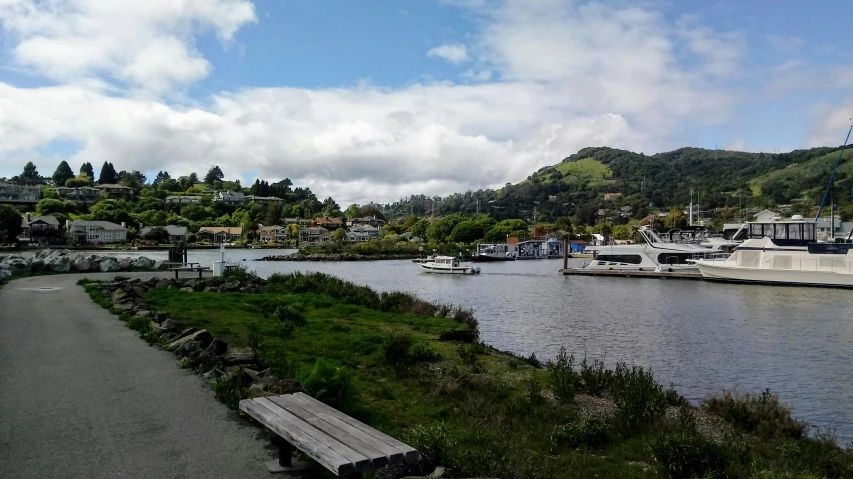 some boats in the water by a paved walkway