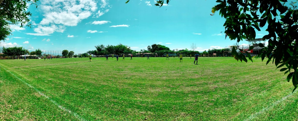 three people play soccer on a grassy field