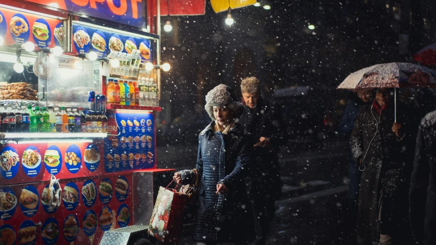 some people standing under an umbrella in the snow