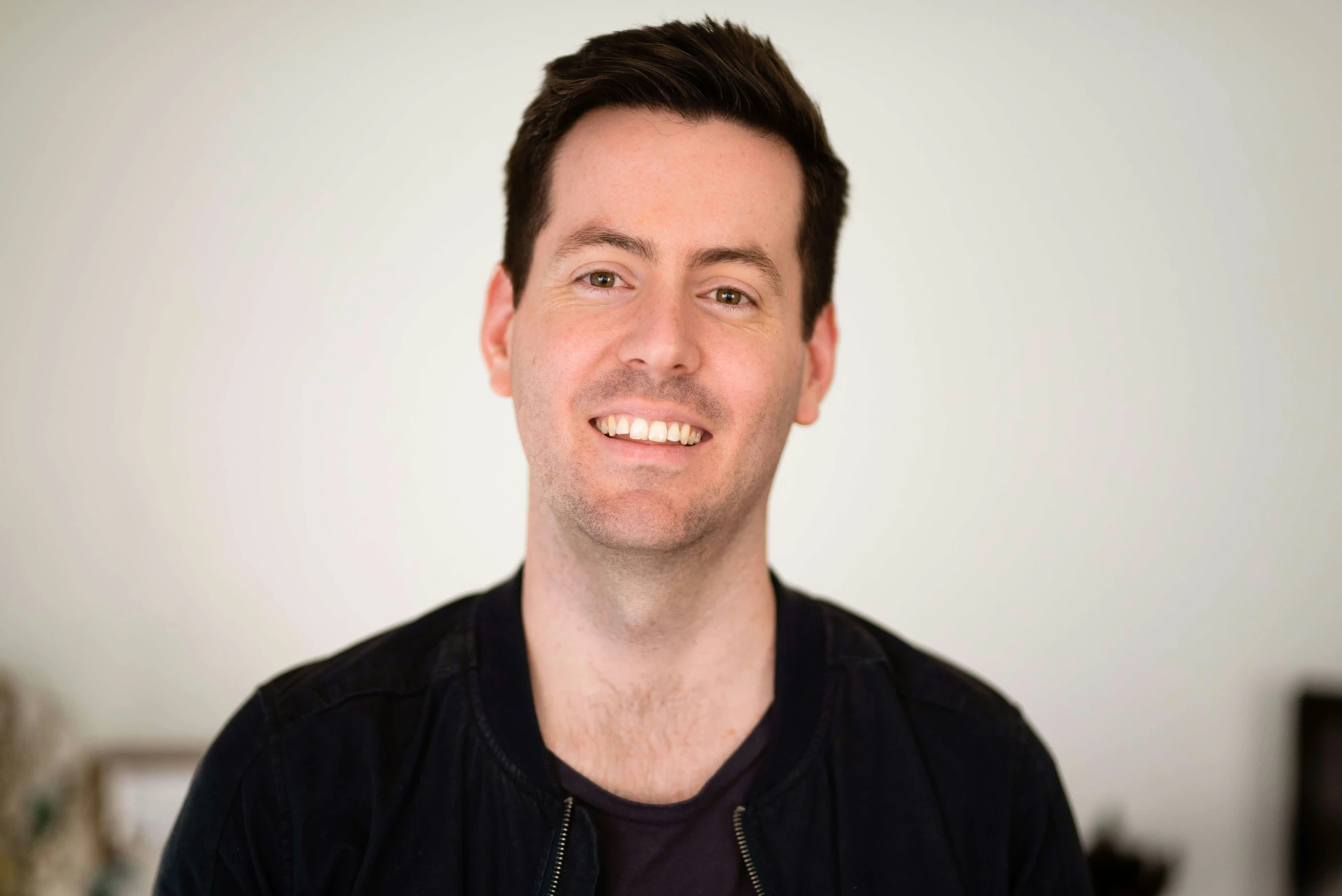 a young man in a black shirt is smiling