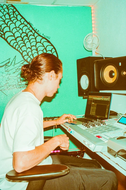 a man working on his laptop in front of some sound equipment