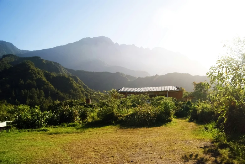 an outside view of a dirt field in front of mountains