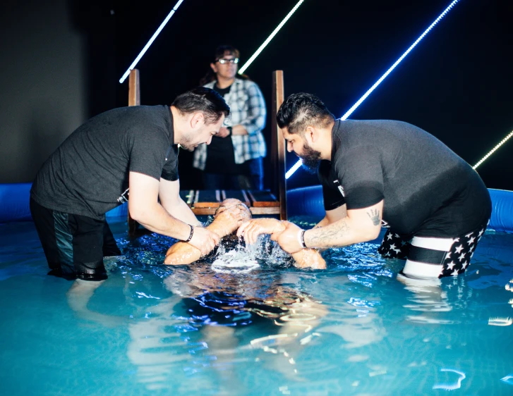 two men playing with soing on top of a pool