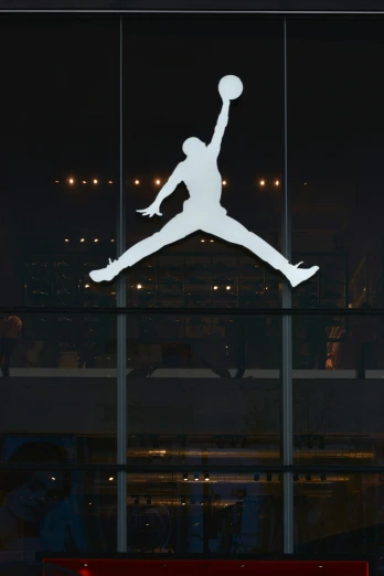a large, white logo hangs from the side of a window