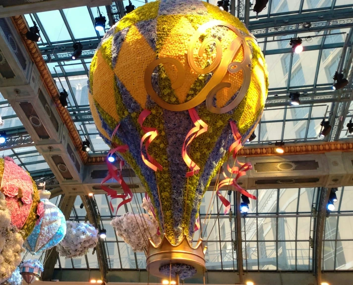 a massive, colorful balloon sculpture in a brightly lit room