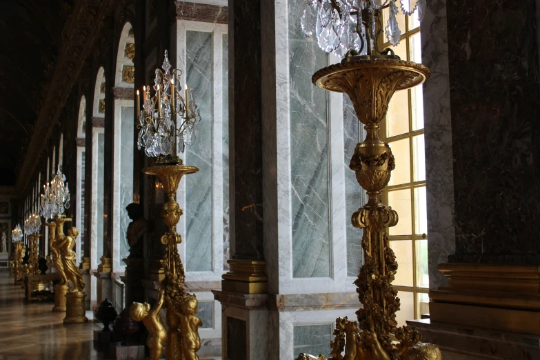 several chandeliers are lined up next to windows