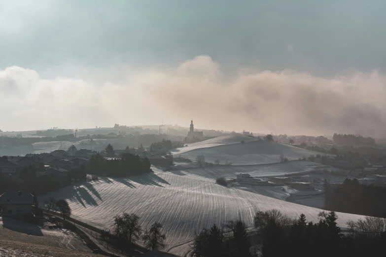 view of a snowy hill top and hills in the distance with houses