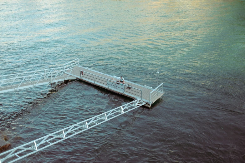 a man standing on top of a pier in the ocean