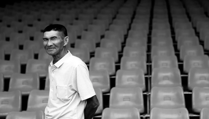 a man standing in front of a row of empty chairs