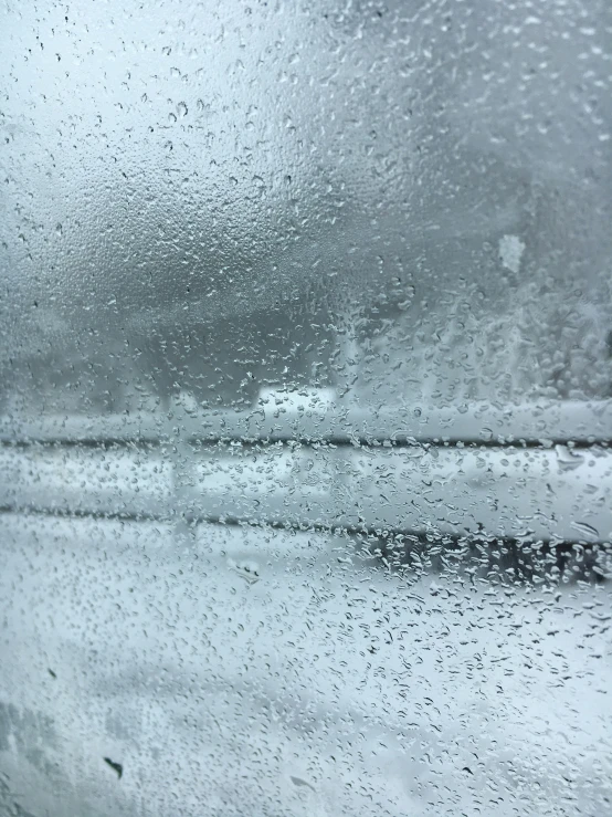 a view outside from inside the car, showing rain on the glass