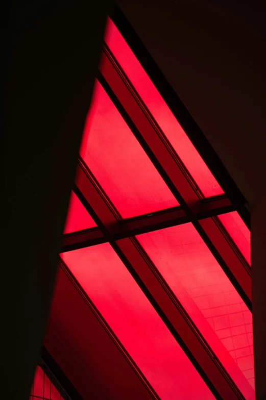 a triangular building with bright red lights at the top