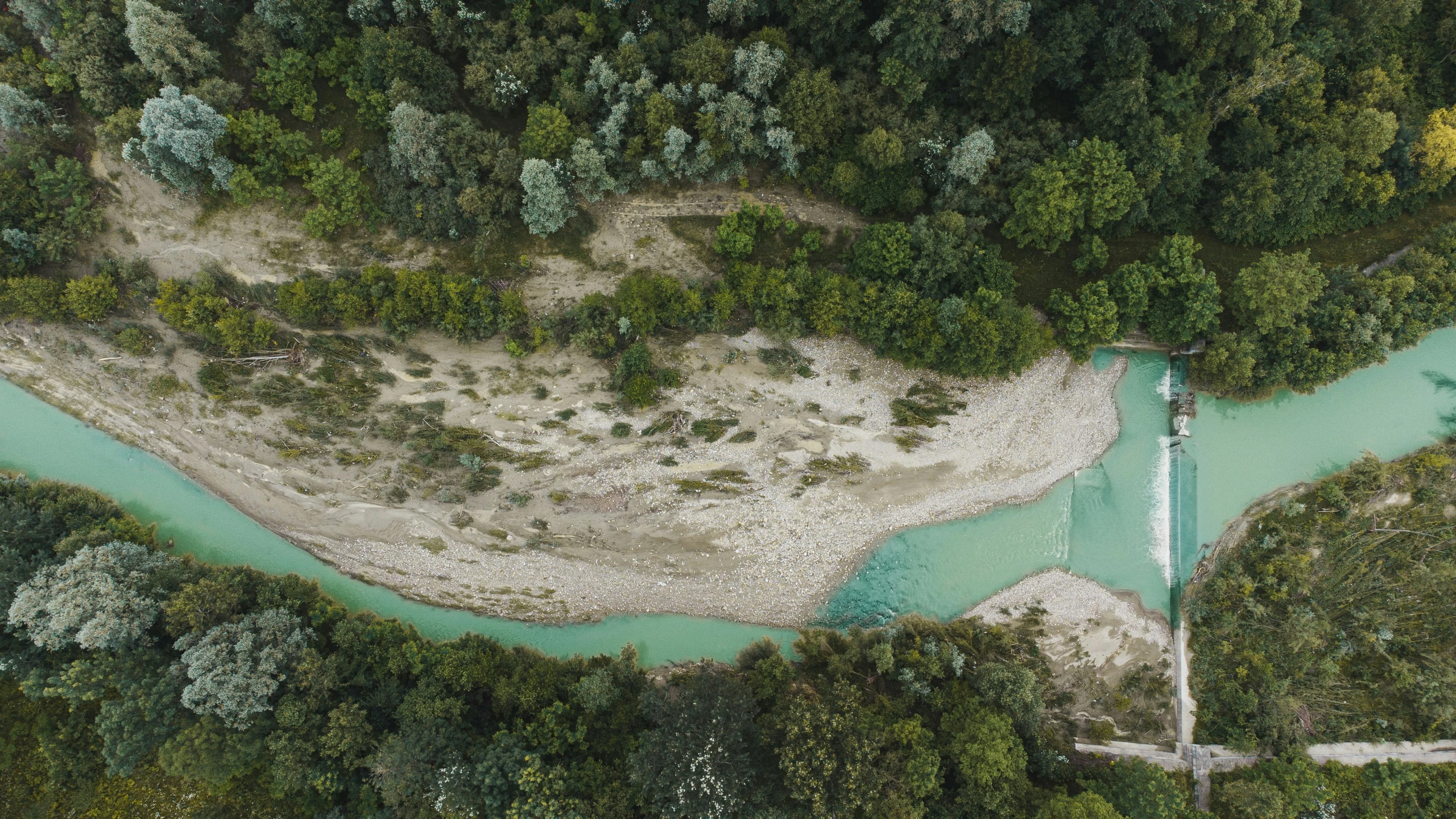 the view of an overhead po of a river and a sandy area