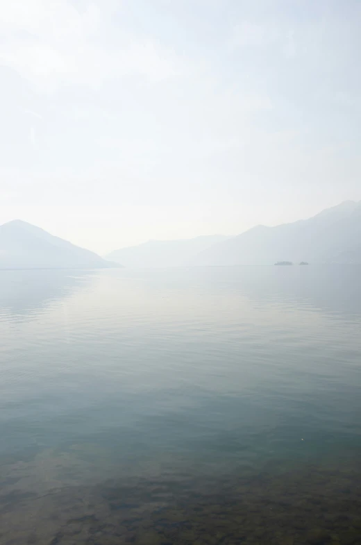 a large body of water surrounded by fog