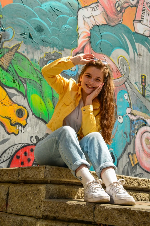 the young woman is posing by a colorful wall