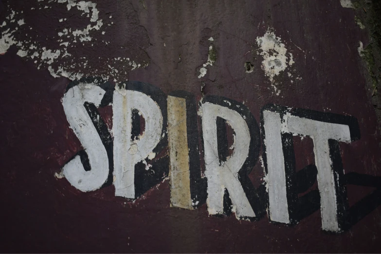 the word spirit written in white paint on an old rusty wall