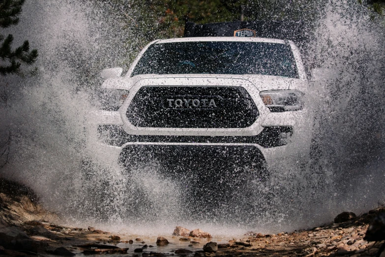 the truck is driving down a trail in the water