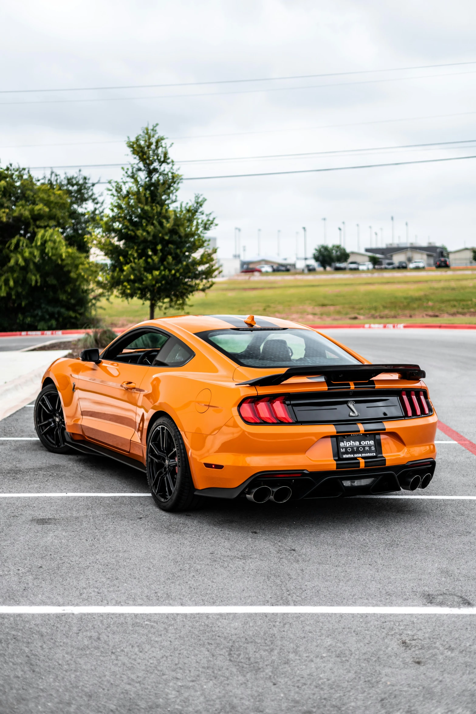 the orange sports car is driving down the road