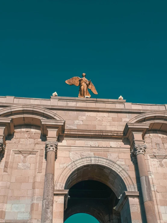 a statue on top of an archway with arches